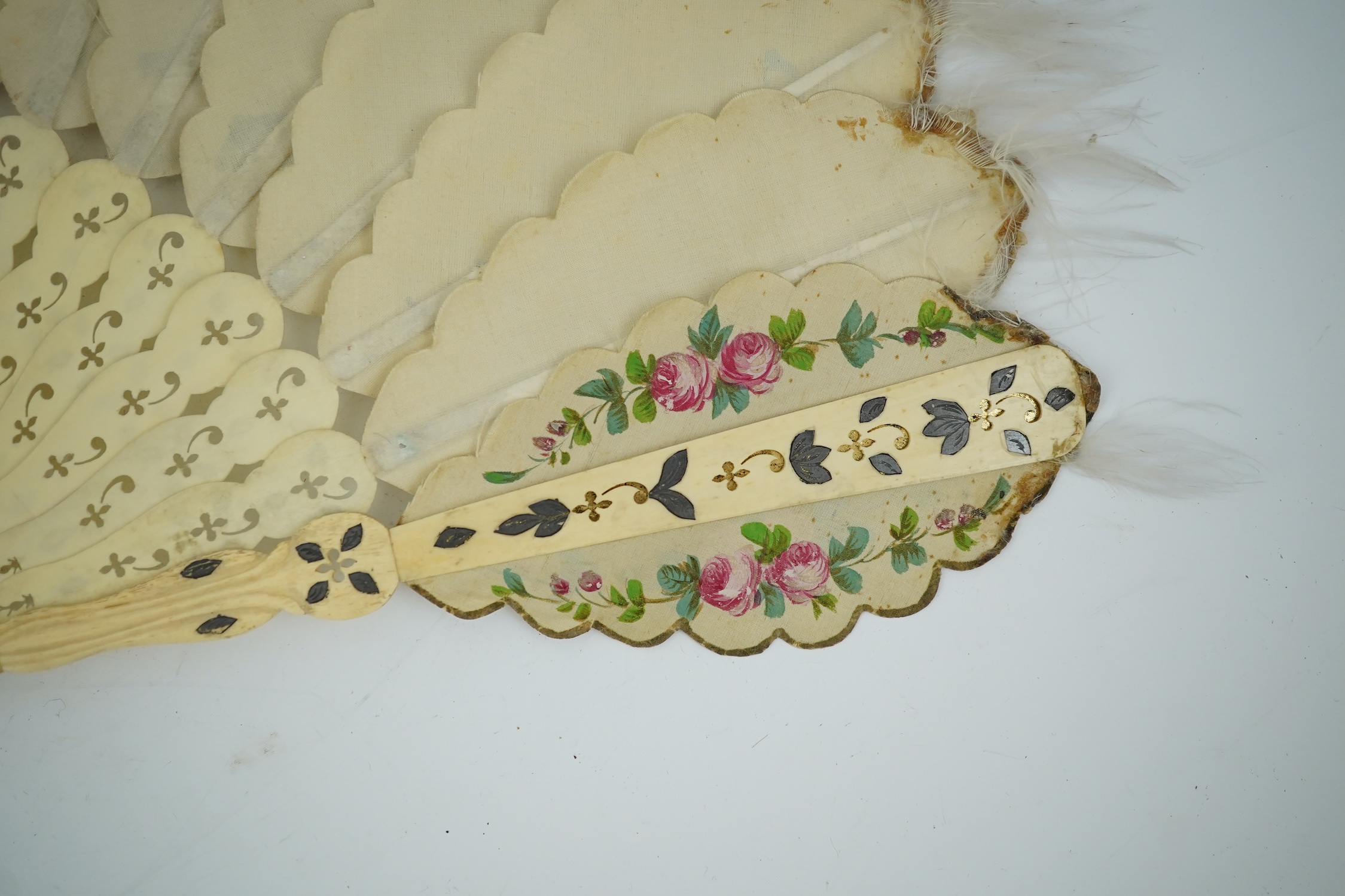 Three French fans: a mother of pearl and sequin fan boxed, a painted silk, feather and bone fan and a gilt decorated bone figural paper fan, the two bone fans having gilt mirrored mounts on the guards, figural paper fan